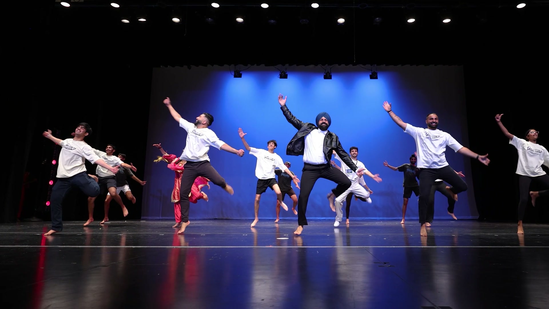 Furteelay dancers mid-leap performing Bhangra on stage